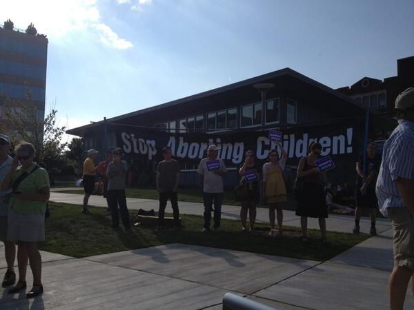 Protesters in front a "stop aborting children" sign
